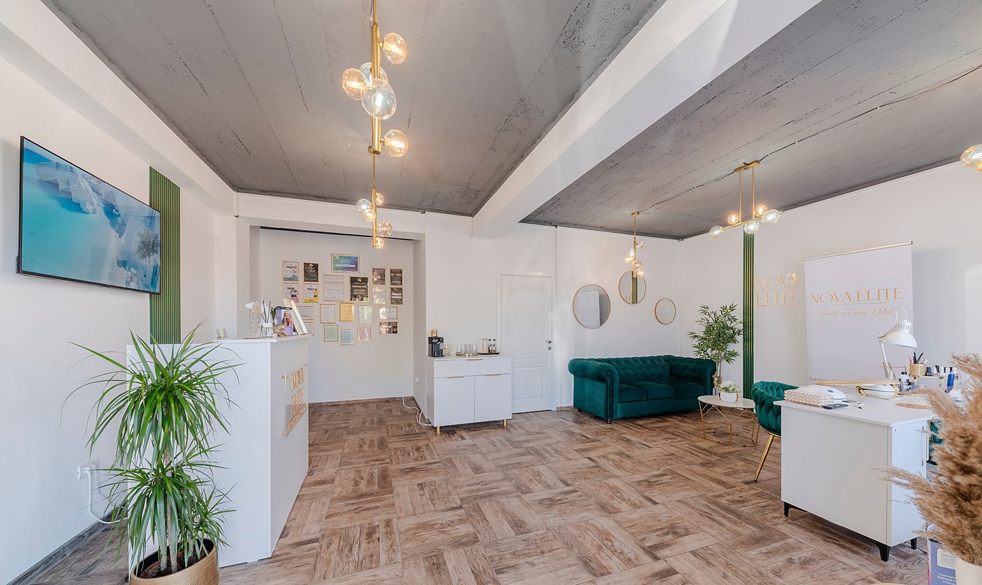 Recepția salonului, cu peretele de diplome, colțul de cafea și canapeaua verde.